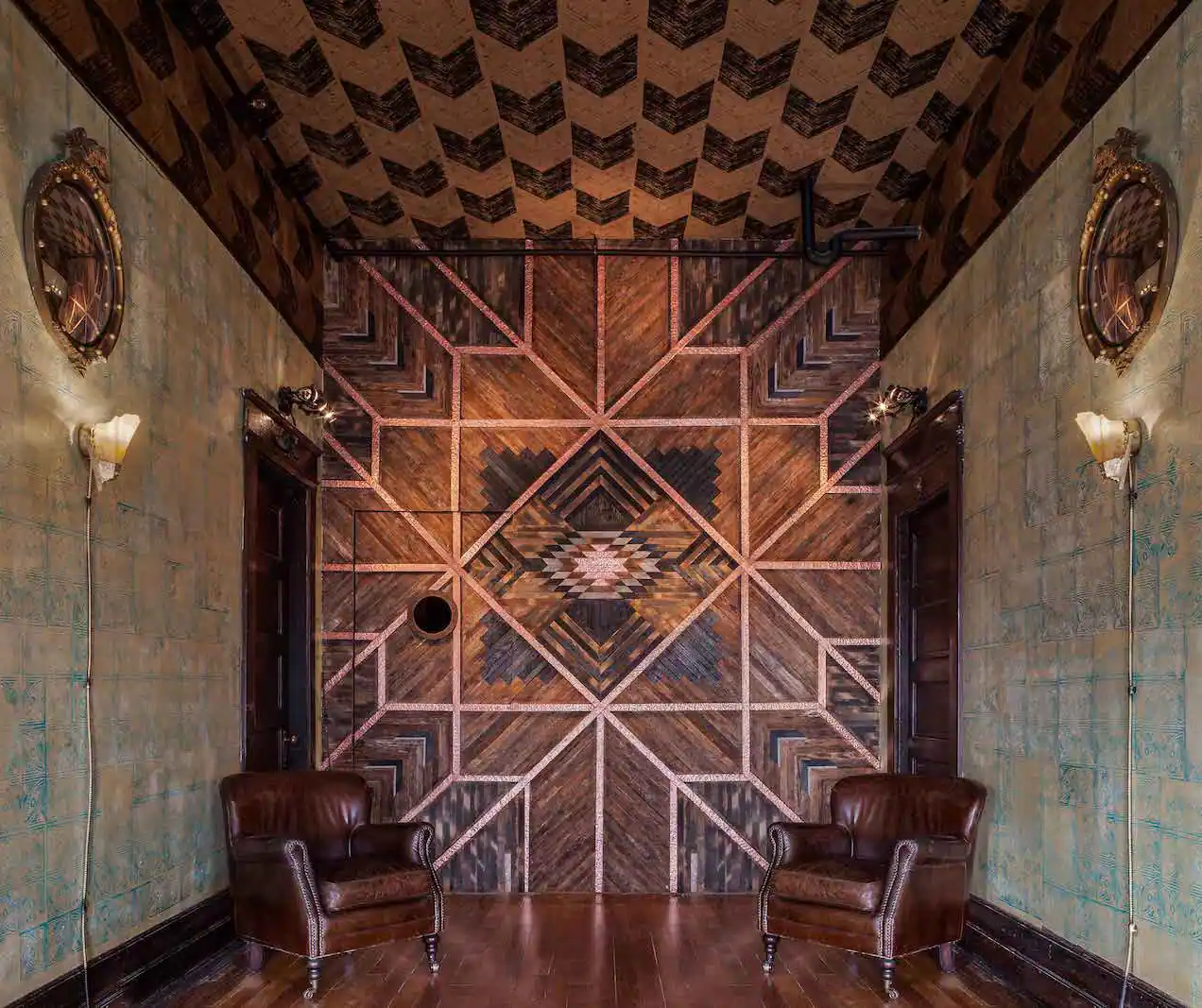 Look into the foyer of Urban Cowboy Nashville. Breaking up a soft patterned wall is warm linework in a Southwestern motif.