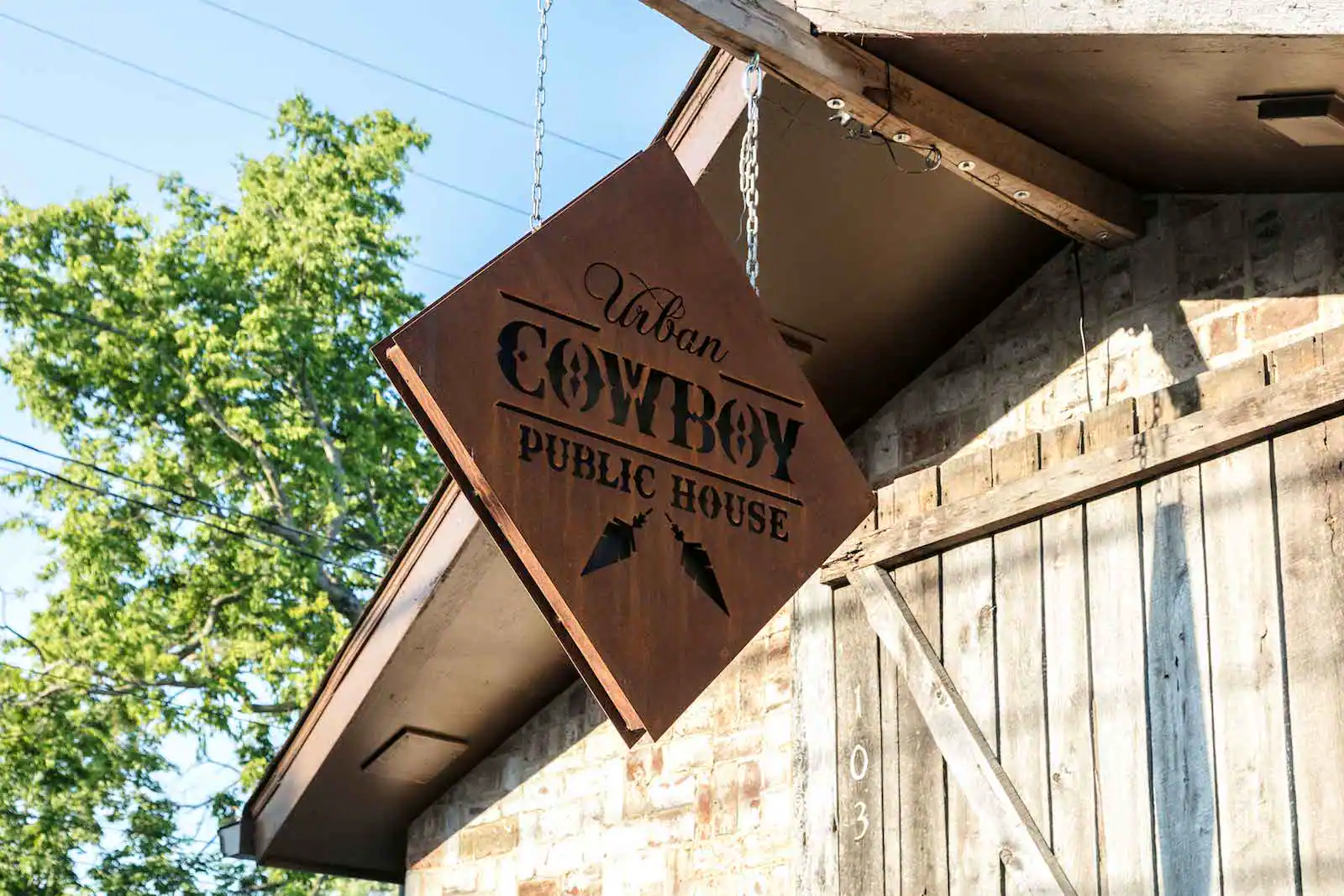 A diamond sign hanging outside the Public House of Urban Cowboy Nashville.